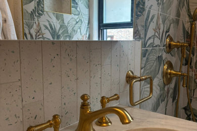 Example of a small eclectic white tile and subway tile powder room design in New York with light wood cabinets, a one-piece toilet, marble countertops, multicolored countertops and a freestanding vanity