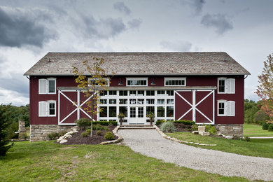 Example of a large farmhouse three-story wood exterior home design in Cleveland