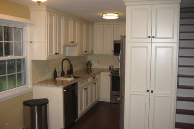 Open concept kitchen - small traditional u-shaped dark wood floor and brown floor open concept kitchen idea in Boston with an undermount sink, beaded inset cabinets, white cabinets, granite countertops, white backsplash, stainless steel appliances, no island and subway tile backsplash