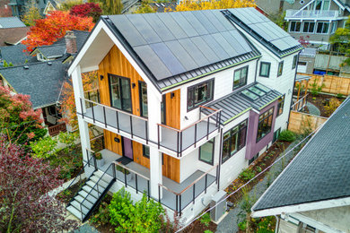 Example of a mid-sized trendy white two-story mixed siding exterior home design in Seattle with a metal roof and a gray roof