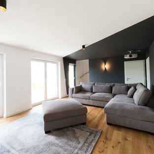 Home theater - modern light wood floor and brown floor home theater idea in Dusseldorf with gray walls