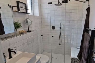 ハンブルクにある高級な中くらいなトラディショナルスタイルのおしゃれなバスルーム (浴槽なし) (フラットパネル扉のキャビネット、白いキャビネット、オープン型シャワー、分離型トイレ、白いタイル、セラミックタイル、白い壁、セラミックタイルの床、ベッセル式洗面器、人工大理石カウンター、マルチカラーの床、開き戸のシャワー、白い洗面カウンター、シャワーベンチ、洗面台1つ、フローティング洗面台、クロスの天井、壁紙) の写真