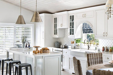 Design ideas for a beach style kitchen in Miami with a farmhouse sink, beaded inset cabinets, white cabinets, quartzite benchtops, multi-coloured splashback, with island and white benchtop.