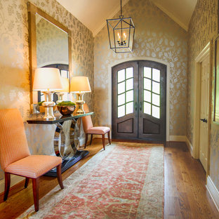 Inredning av en eklektisk mellanstor ingång och ytterdörr, med mellanmörkt trägolv, en dubbeldörr och metalldörr