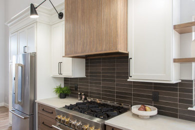 Mid-sized minimalist l-shaped medium tone wood floor open concept kitchen photo in Denver with an undermount sink, shaker cabinets, medium tone wood cabinets, quartz countertops, black backsplash, ceramic backsplash, stainless steel appliances, an island and beige countertops