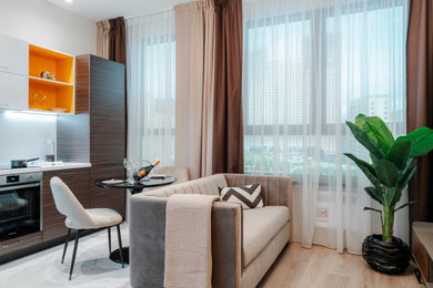 На фото: гостиная комната в современном стиле с бежевыми стенами и полом из ламината с