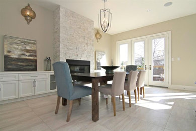 Mid-sized trendy travertine floor and beige floor kitchen/dining room combo photo in Toronto with beige walls, a standard fireplace and a stone fireplace
