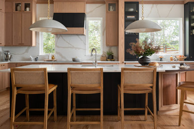 Kitchen - mid-sized transitional u-shaped medium tone wood floor kitchen idea in Denver with an undermount sink, shaker cabinets, medium tone wood cabinets, quartz countertops, white backsplash, quartz backsplash, paneled appliances, an island and white countertops