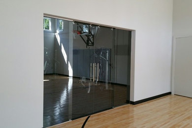 Example of a mid-sized trendy light wood floor and beige floor indoor basketball/tennis/multi-game court design in Minneapolis with gray walls