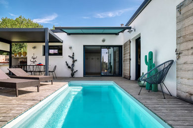 Cette photo montre un couloir de nage latéral tendance de taille moyenne et rectangle avec une terrasse en bois.