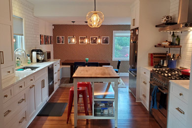 Example of a mid-sized arts and crafts galley eat-in kitchen design in Seattle with shaker cabinets, white cabinets, quartz countertops, white backsplash, an island and white countertops