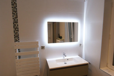 This is an example of a medium sized traditional ensuite bathroom in Nancy with beaded cabinets, beige cabinets, a submerged bath, a shower/bath combination, a wall mounted toilet, multi-coloured tiles, ceramic tiles, white walls, ceramic flooring, a wall-mounted sink, brown floors, a hinged door and white worktops.