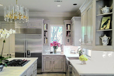 Large elegant u-shaped kitchen photo in Houston with marble countertops, marble backsplash, stainless steel appliances, an island, white countertops and light wood cabinets
