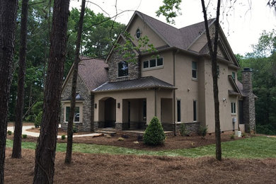 Design ideas for a two-storey stucco beige exterior in Charlotte with a gable roof.