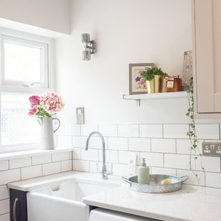 Design ideas for a small rural galley utility room in Other with a belfast sink, shaker cabinets, blue cabinets, beige walls, ceramic flooring, a side by side washer and dryer, blue floors and grey worktops.