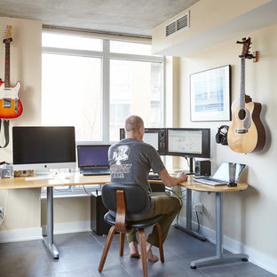 Photo of a medium sized modern study in Toronto with yellow walls, concrete flooring and a freestanding desk.