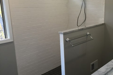 Imagen de cuarto de baño principal minimalista de tamaño medio con armarios estilo shaker, puertas de armario de madera en tonos medios y baldosas y/o azulejos grises