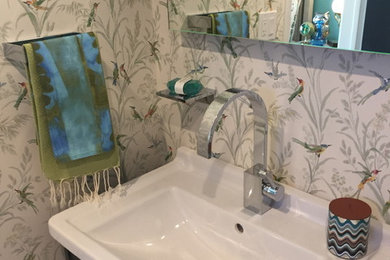 Walk-in shower - small contemporary 3/4 white tile and porcelain tile porcelain tile walk-in shower idea in San Diego with an integrated sink, furniture-like cabinets, gray cabinets, solid surface countertops, a one-piece toilet and multicolored walls