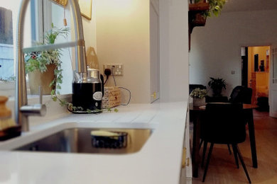 Inspiration for a large scandinavian kitchen in Glasgow with a built-in sink, shaker cabinets, quartz worktops, light hardwood flooring, no island and white worktops.