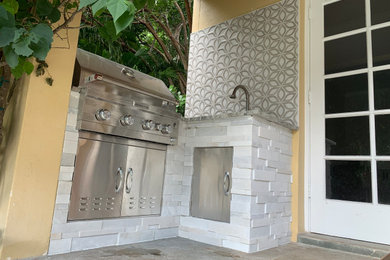 Mid-sized trendy backyard concrete paver patio kitchen photo in Miami with a roof extension