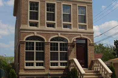 Large elegant brown three-story brick exterior home photo in Chicago
