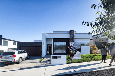 Inspiration for a large contemporary one-storey brick white house exterior in Canberra - Queanbeyan with a flat roof, a metal roof and a grey roof.
