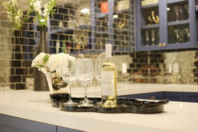 This is an example of a contemporary home bar in San Francisco with shaker cabinets, blue cabinets, quartz benchtops, mirror splashback, grey floor and white benchtop.