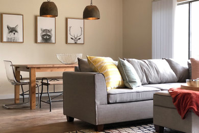 Diseño de salón abierto con paredes beige y suelo de madera en tonos medios