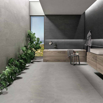 Modern grey bathroom with grey porcelain tiles and wood vanity and bathtub