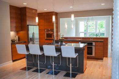 Kitchen - contemporary light wood floor and brown floor kitchen idea in Other with an undermount sink, flat-panel cabinets, medium tone wood cabinets, stainless steel appliances, white backsplash and two islands