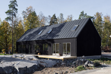 Bild på ett mellanstort nordiskt svart hus, med allt i ett plan och sadeltak