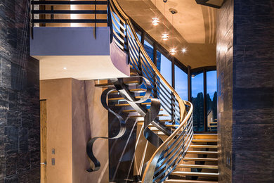 Example of a huge minimalist wooden curved staircase design in Seattle with metal risers