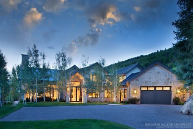 Example of a trendy beige stone house exterior design in Denver