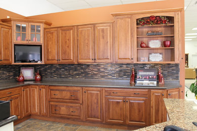 Inspiration for a large l-shaped enclosed kitchen remodel in Other with an undermount sink, raised-panel cabinets, medium tone wood cabinets, laminate countertops, black appliances and an island