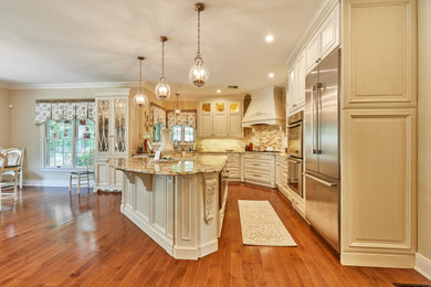 L-shaped medium tone wood floor and brown floor eat-in kitchen photo in New York with raised-panel cabinets, beige cabinets, granite countertops, stainless steel appliances, an island and beige countertops