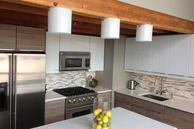 Inspiration for a contemporary l-shaped eat-in kitchen remodel in San Francisco with a single-bowl sink, flat-panel cabinets, white cabinets, quartz countertops, beige backsplash, subway tile backsplash, stainless steel appliances and an island