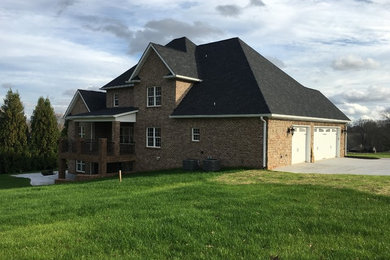 Mid-sized transitional beige two-story brick exterior home idea in Raleigh with a hip roof