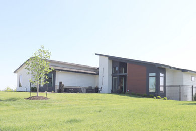 1950s one-story mixed siding house exterior photo in Omaha with a butterfly roof, a shingle roof and a black roof