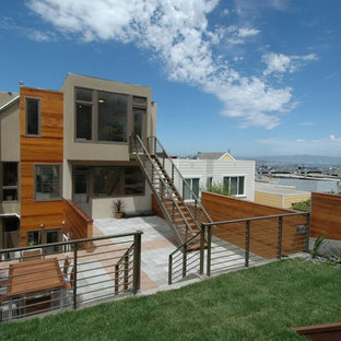 Exempel på ett stort modernt grått trähus, med tre eller fler plan