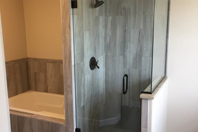 Inspiration for a mid-sized transitional master bathroom in Denver with a drop-in tub, a corner shower, gray tile, mosaic tile, grey walls, ceramic floors, grey floor and a hinged shower door.
