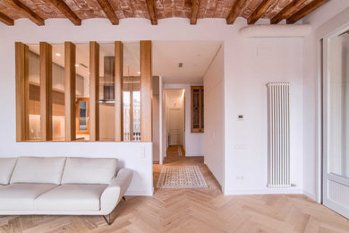 This is an example of a mid-sized eclectic open concept living room in Barcelona with a library, white walls, medium hardwood floors, a wall-mounted tv, beige floor, exposed beam and brick walls.