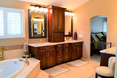 Design ideas for a large traditional master bathroom in Denver with raised-panel cabinets, dark wood cabinets, beige tile, travertine and granite benchtops.