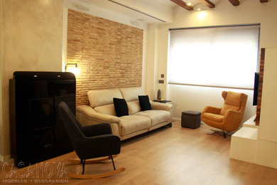 Modelo de salón abierto moderno grande con paredes blancas, suelo laminado y televisor colgado en la pared