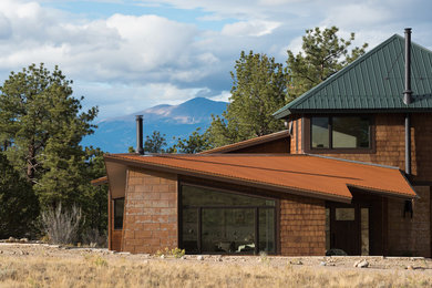 This is an example of a large modern two-storey brown house exterior in Denver with mixed siding, a shed roof and a metal roof.