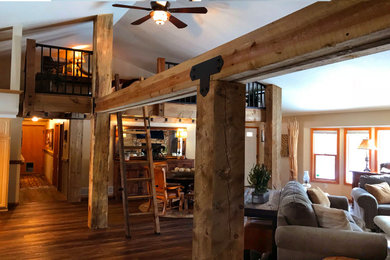 Design ideas for a rustic mezzanine living room in Denver with vinyl flooring, a corner fireplace, a stone fireplace surround, a vaulted ceiling and wood walls.