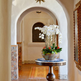 Entryway - huge southwestern ceramic floor and orange floor entryway idea in San Diego with white walls and a glass front door