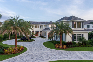 Huge white two-story stucco house exterior photo in Miami with a tile roof