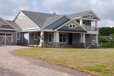 Inspiration for a large craftsman multicolored two-story wood house exterior remodel in Tampa with a shingle roof