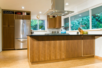 This is an example of a modern u-shaped eat-in kitchen in Seattle with a farmhouse sink, flat-panel cabinets, dark wood cabinets, white splashback, ceramic splashback and stainless steel appliances.