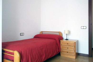 Imagen de dormitorio principal pequeño con paredes blancas, suelo de baldosas de cerámica y suelo beige